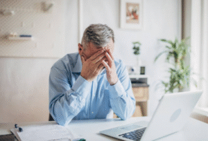 stressed man at desk with head in his hands