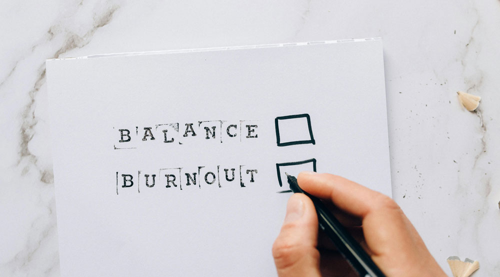 piece of paper with balance or burnout and ticks boxes